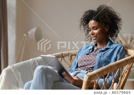 Happy young African American woman using digital computer tablet. 86579664