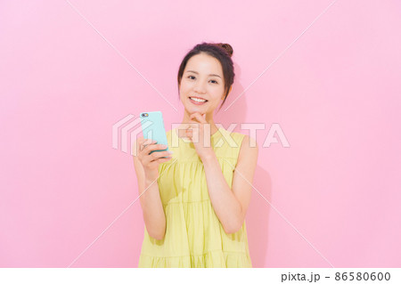 スマホ 女性 ピンク背景 スマホ 女性 ピンク背景 86580600