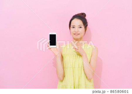 スマホ 女性 ピンク背景 スマホ 女性 ピンク背景 86580601