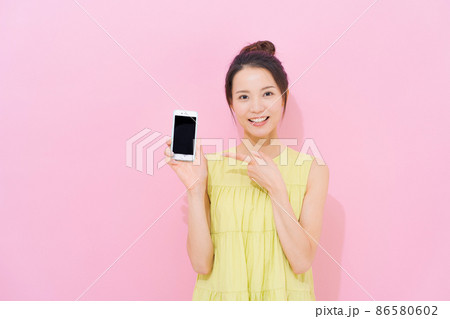 スマホ　女性　ピンク背景 86580602