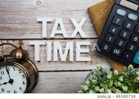 Tax Time alphabet letters with calculator and alarm clock on wooden background 86580738