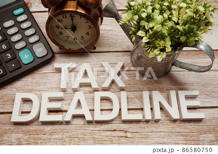 Tax Deadline alphabet letters with calculator and alarm clock on wooden background 86580750