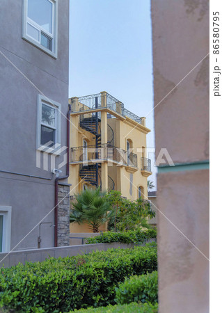 View of a yellow building with outdoor spiral staircase at Oceanside, California View of a yellow building with outdoor spiral staircase at Oceanside, California 86580795