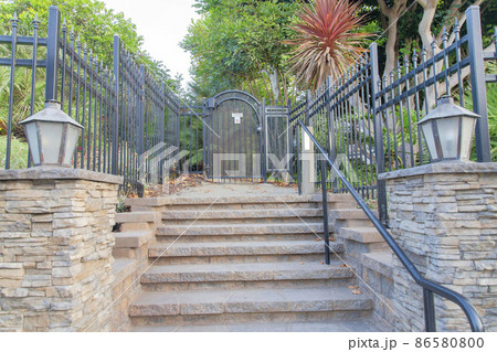 Wrought iron gate and fence with a view of trees and plants at Oceanside, California 86580800