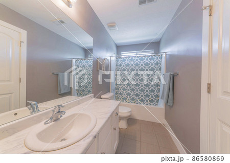 Bathroom interior with gray walls and window near the bathtub 86580869