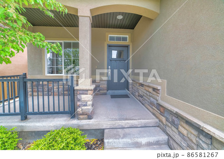 Porch exterior of a house with stone veneer siding and metal railings 86581267