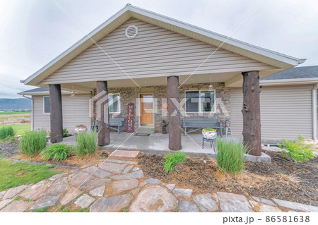 Exterior of a house with vinyl wood siding and log column posts Exterior of a house with vinyl wood siding and log column posts 86581638