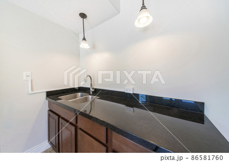 Kitchen sink with black granite top and dark wood drawers and cabinets Kitchen sink with black granite top and dark wood drawers and cabinets 86581760
