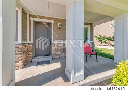 Porch of a house with white column posts and red arm chair 86582016