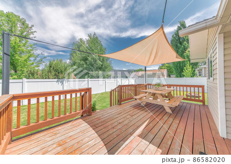 Wooden deck with a sunshade over the table with bench seats Wooden deck with a sunshade over the table with bench seats 86582020