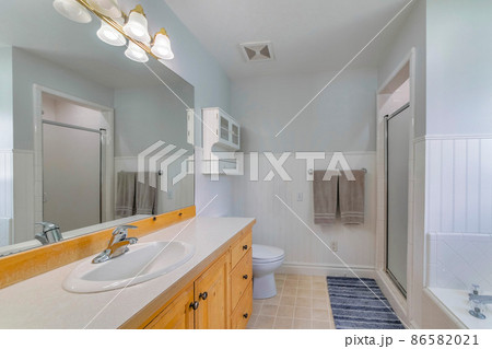 Bathroom interior with wooden vanity sink and wall cabinet storage 86582021