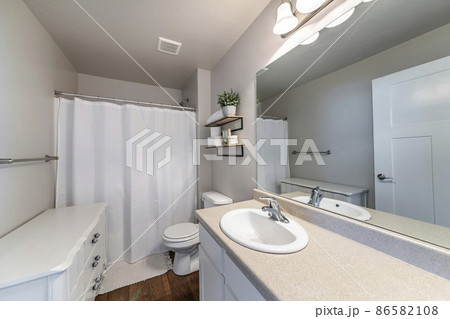 Interior of a bathroom with white floor cabinet and vanity sink 86582108