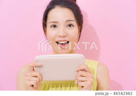 20代女性　ピンク背景　財布 86582962