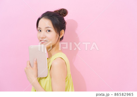 20代女性　ピンク背景　財布 86582965