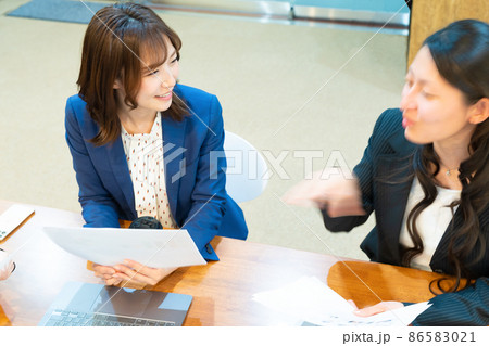 オフィスで会話や会議をする女性スタッフ 86583021