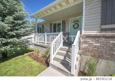 Traditional house entrance with a large pine tree at the front yard Traditional house entrance with a large pine tree at the front yard 86583216