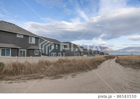 Offroad trail with tall grasses outside the fenced residential area Offroad trail with tall grasses outside the fenced residential area 86583550
