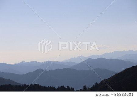 連なる山々の先に輝く海面の海と白む空と青空の風景 連なる山々の先に輝く海面の海と白む空と青空の風景 86583601