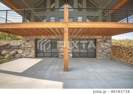 Two glass garage door of a modern custom house with stone veneer siding Two glass garage door of a modern custom house with stone veneer siding 86583738