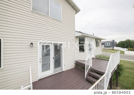 Outdoor veranda with wooden flooring and white railings Outdoor veranda with wooden flooring and white railings 86584003