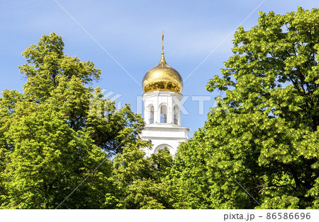 Golden dome of an orthodox church among the trees of the city park 86586696