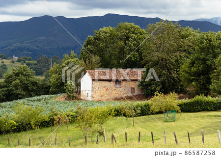 Scenic view of valley in Asturias with traditional farm building Scenic view of valley in Asturias with traditional farm building 86587258