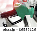 Close up green nozzle filling up a gas tank 86589126