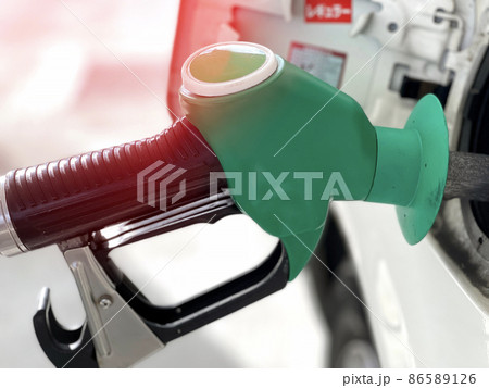 Close up green nozzle filling up a gas tank 86589126