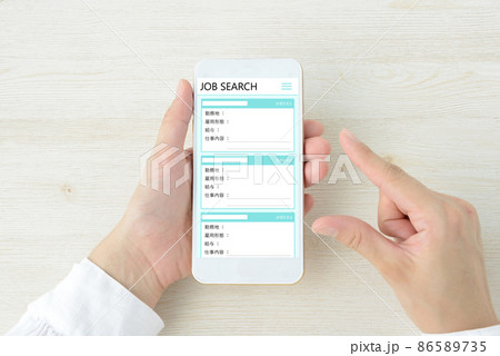 スマートフォンで仕事を探す人物の手元 86589735