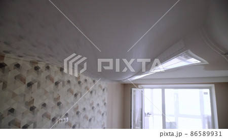 Stretch ceiling in the room filled with water. Flood, water leakage from the ceiling in the apartment. 86589931