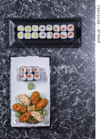 set of sushi rolls with seafood on a black stone background 86591661