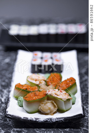 set of sushi rolls with seafood on a black stone background set of sushi rolls with seafood on a black stone background 86591662