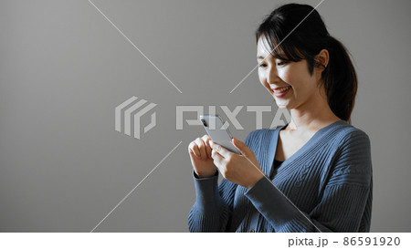 携帯電話を操作する若い女性 携帯電話を操作する若い女性 86591920