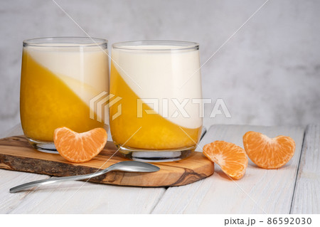 Glass of Tangerine panna cotta dessert with mandarin slices. 86592030