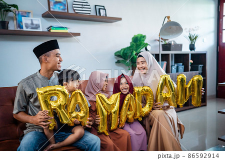 family wearing muslim traditional clothes holding a text of ramadan family wearing muslim traditional clothes holding a text of ramadan 86592914