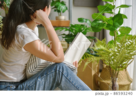 Woman chilling and reading in living room, Artificial plant, Fiddle leaf fig tree, Woman chilling and reading in living room, Artificial plant, Fiddle leaf fig tree, 86593240