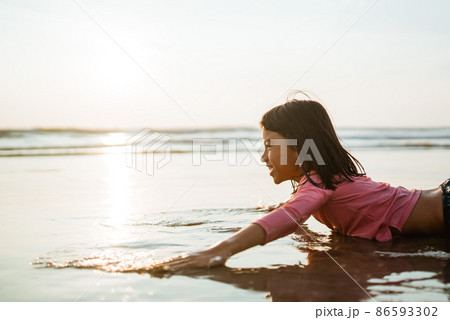 asian child playing laying in the beach enjoy the sunset asian child playing laying in the beach enjoy the sunset 86593302