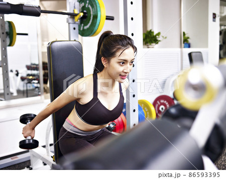 young asian woman working out exercising in gym using dumbbells 86593395