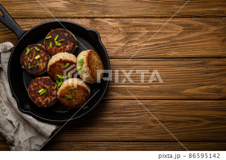 Homemade cutlets from fish, chicken or meat on black cast iron frying pan skillet Homemade cutlets from fish, chicken or meat on black cast iron frying pan skillet 86595142
