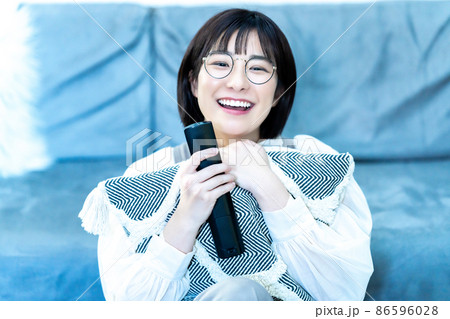 リビングでテレビを観る若い眼鏡の女性 リビングでテレビを観る若い眼鏡の女性 86596028