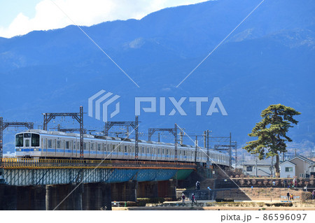 箱根の山を背景に鉄橋を渡る小田急電鉄1000形通勤電車 箱根の山を背景に鉄橋を渡る小田急電鉄1000形通勤電車 86596097