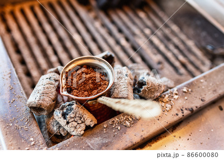 Brewing turkish coffee in cezve on a coal stove Brewing turkish coffee in cezve on a coal stove 86600080
