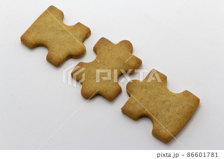 closeup of the jigsaw, puzzle shaped cookies white background, horizontal copy space pastry background. Team building, banner 86601781