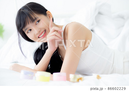 Beautiful of young asian woman smiling and lying on bed at bedroom, beauty of girl touch cheek. Beautiful of young asian woman smiling and lying on bed at bedroom, beauty of girl touch cheek. 86602229