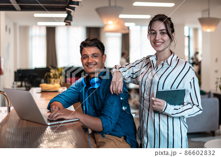 Multiethnic business people man with a female colleague working together on tablet and laptop computer in relaxation area of modern startup office 86602832