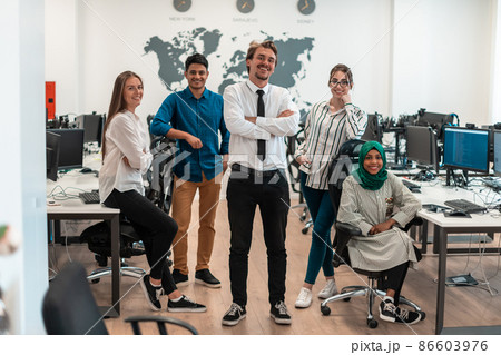 Portrait of young excited multiethnics business team of software developers standing and looking at camera at modern startup office Portrait of young excited multiethnics business team of software developers standing and looking at camera at modern startup office 86603976