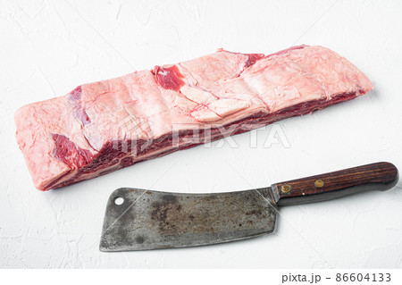 Short Ribs Bone In stew, and old butcher cleaver knife, on white stone background Short Ribs Bone In stew, and old butcher cleaver knife, on white stone background 86604133