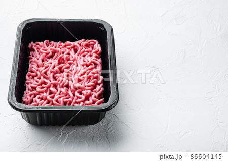 Minced meat in packaging, on white stone background, with copy space for text 86604145