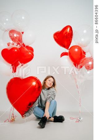 an blonde woman with balloons on a white background.  86604396