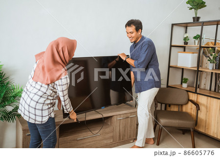 muslim Couple Carrying Flat Television Screen In Their Modern House muslim Couple Carrying Flat Television Screen In Their Modern House 86605776